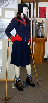 [Mannequin of a woman dressed in ski gear of years ago which included wearing a skirt instead of leggins.]